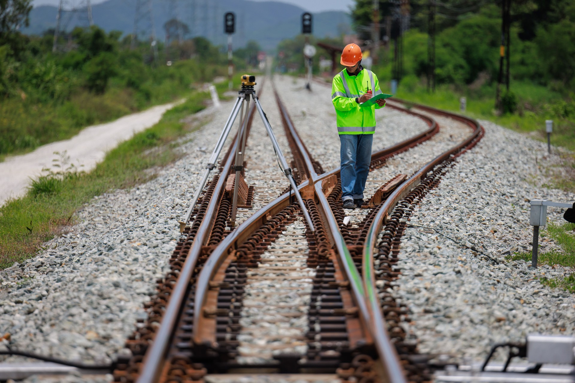 Engineer use theodolite equipment surveying construction worker on Railway site.